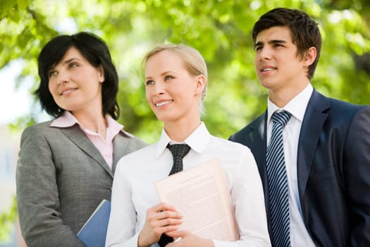 Portrait of confident business group looking aside in natural environment