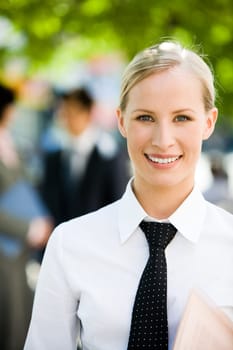 Portrait of pretty employer looking at camera with smile outside