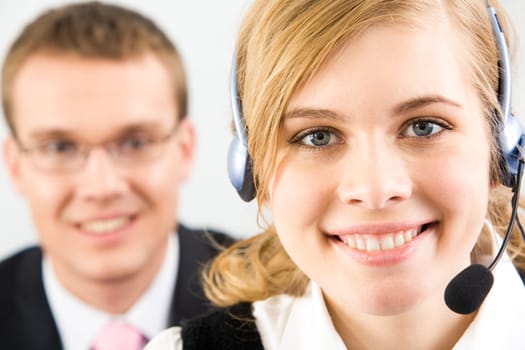 Face of pretty secretary wearing headset on background of confident businessman