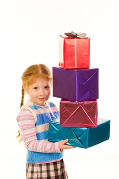 Portrait of little girl with pile of Christmas gifts in hands looking at camera