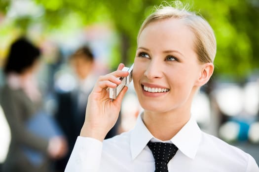 Portrait of pretty business leader talking by mobile phone with smile