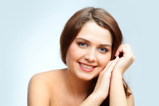 Portrait of charming girl touching her face and looking at camera