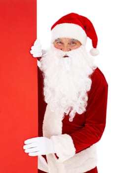 Photo of happy Santa Claus peeking out of red billboard
