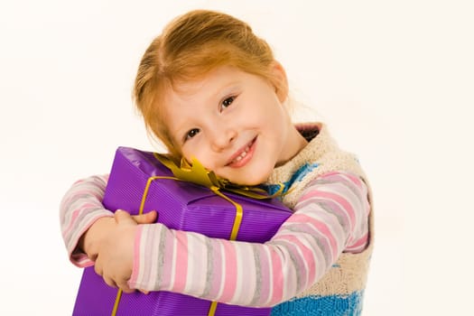 Portrait of cute child with big violet giftbox smiling and looking at camera