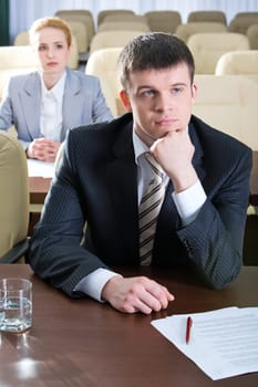 Portrait of a successful man sitting at the table in the conference room