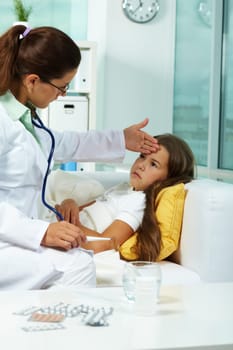 Portrait of clinician with thermometer touching forehead of sick girl