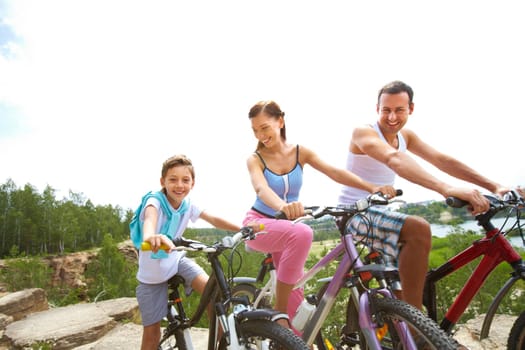 Portrait of family of three on bikes outdoors