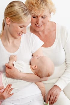 Portrait of two women looking at sleeping baby in mother hands