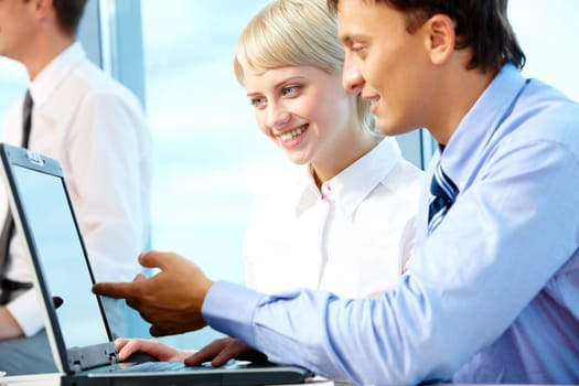 Portrait of executive partners looking at laptop during meeting