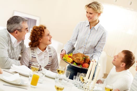 Portrait of senior couple and happy man pretty woman with roasted turkey going to put it on festive table