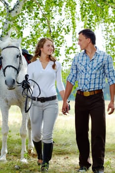 Image of happy woman surrounded by purebred horse and her sweetheart during walk