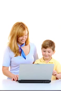 Photo of cute preschooler and his mother working with laptop