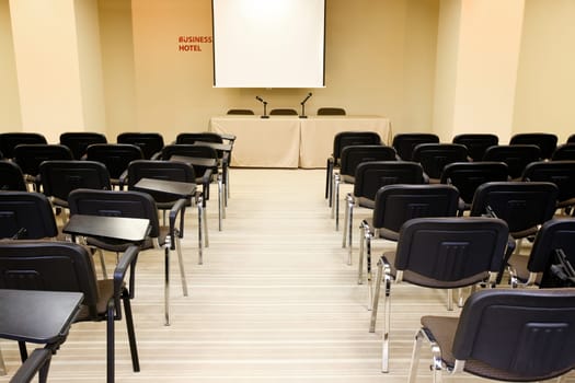 Image of several rows of armchairs in conference hall