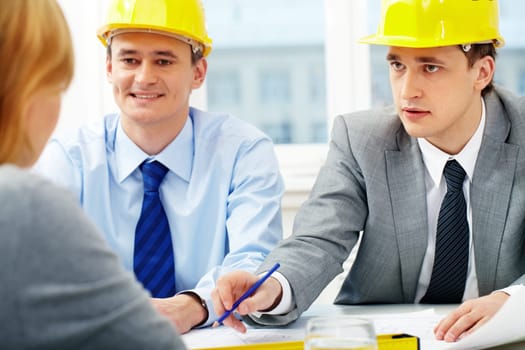 Two architects talking to their colleagues