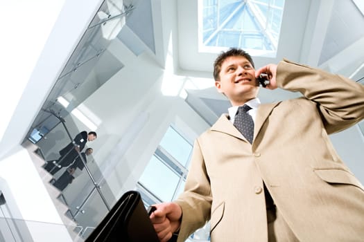 Image of busy successful man in suit in the modern office block