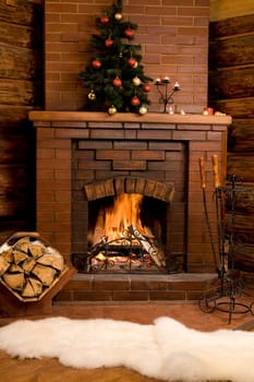 Photo of fireplace with firewood and warm white fur near by