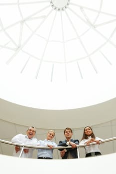 Creative image of happy business group standing together in the business hall