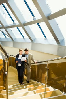 Business women  showing research results  to boss in the corridor
