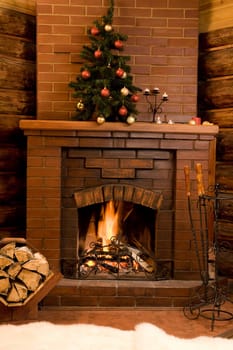 Image of hot fire in chimney with fir tree decorated before Christmas