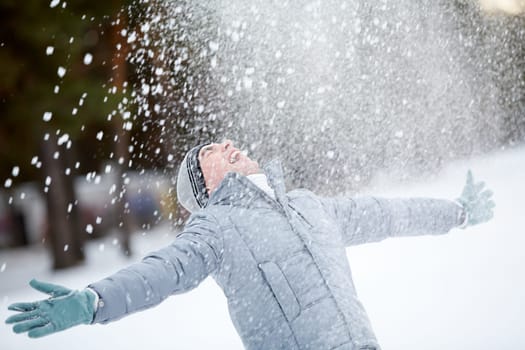Portrait of cute guy taking pleasure on snowy winter day