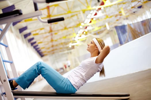 A girl pumping abdominal muscles in gym