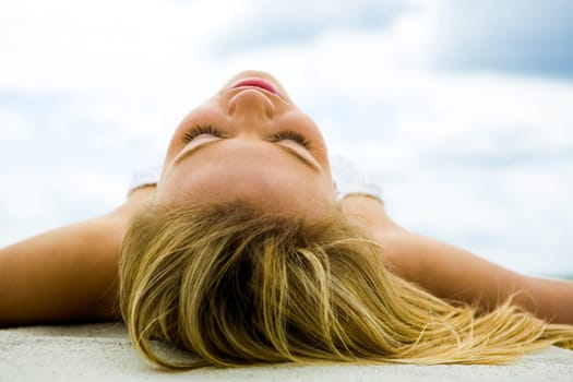 Image of serene female sunbathing on sand