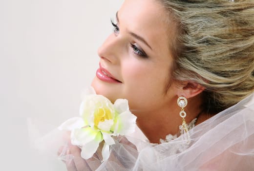 Portrait of pretty bride holding bright flower