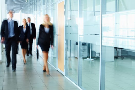 Several businesspeople walking in the corridor