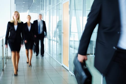 Business people walking along the office corridor