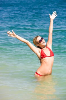Photo of joyful woman standing in water and enjoying summer vacation