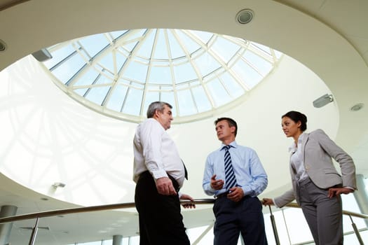 Portrait of three partners discussing ideas at meeting