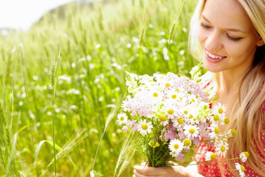 Portrait of young woman holding bunch of flowers outside