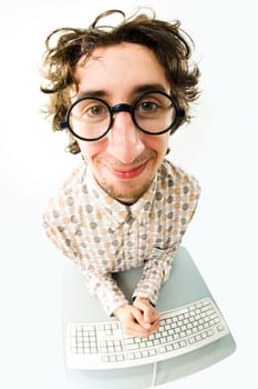 View from above of man in glasses sitting at desk with keyboard on it