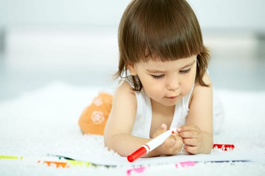 Portrait of cute girl holding highlighter at home