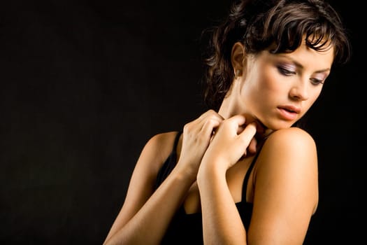 Portrait of sensual woman holding her hands near neck