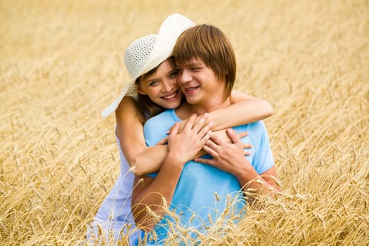 Portrait of beautiful woman with hat embracing her boyfriend