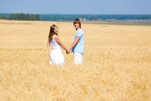 Portrait of two people standing together in wheat field