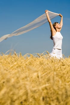 Image of golden wheat on the background of enjoying woman