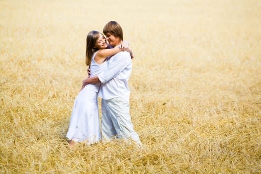 Photo of happy couple embracing in wheat field