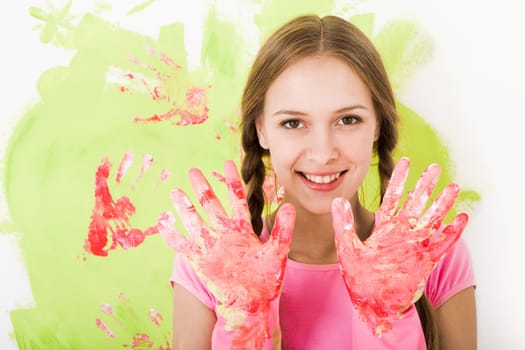 Image of joyful girl showing her hands in rubber gloves and smiling at camera