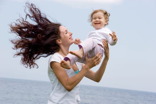 Joyful female playing with adorable infant on fresh air at summer