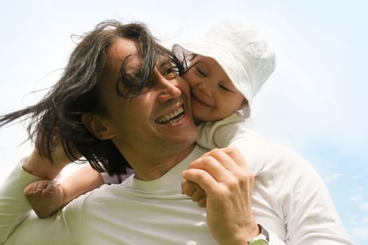 Portrait of happy man with his daughter laughing somewhere outdoors