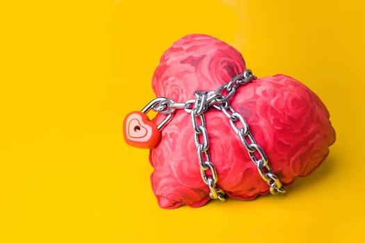 Creative image of soft toy heart bound with chain and small padlock