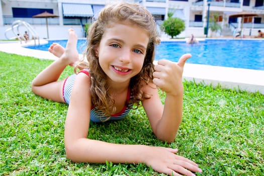 children girl lying on grass in pool during summer vacation