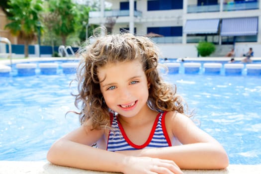 happy kid girl smiling at swimming pool in summer vacation