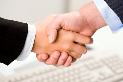 Photo of handshake of business partners after signing promising contract
