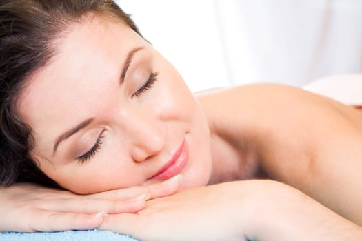 Beautiful woman with her eyes shut having rest in the spa salon
