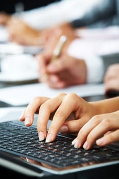 Photo of females hands touching keys of laptop during briefing on background of human hands