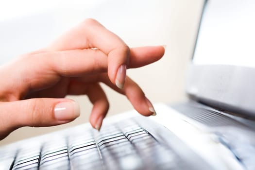 Close-up of female hand keeping forefinger bound while pointing at laptop display