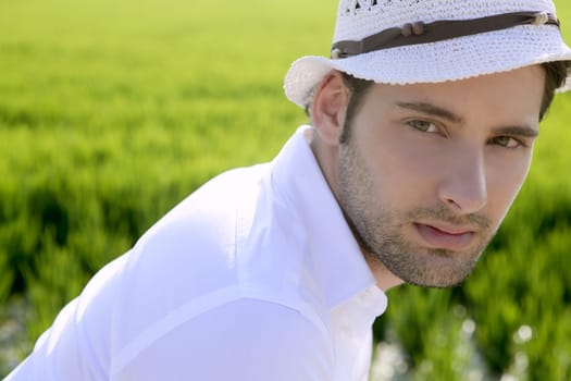 Mediterranean man portrait white hat in green meadow rice field